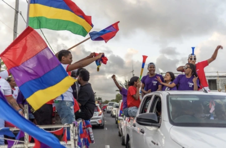 Des partisans de l'Alliance du Changement, menée par le leader de l'opposition Navin Ramgoolam, fêtent l'annonce des premiers résultats des élections législatives à l'île Maurice, le 11 novembre 2024 à Plaine Magnien ( AFP / Laura Morosoli )