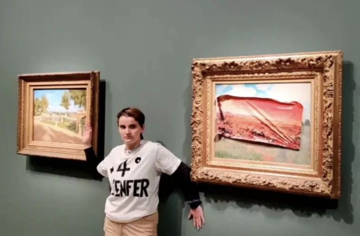 Photo diffusée par le collectif écologiste "Riposte alimentaire", le 1er juin 2024, montrant une militante interpellée après une action contre le tableau "Les Coquelicots" de Claude Monet au Musée d'Orsay, à Paris ( Riposte Alimentaire / Handout )