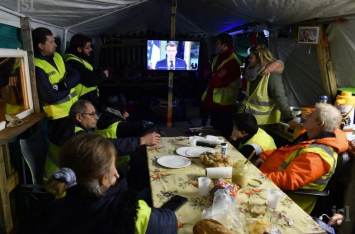 Des gilets jaunes regardent l'allocution télévisée d'Emmanuel Macron dans un restaurant à Fay-aux-Loges, le 10 décembre 2018