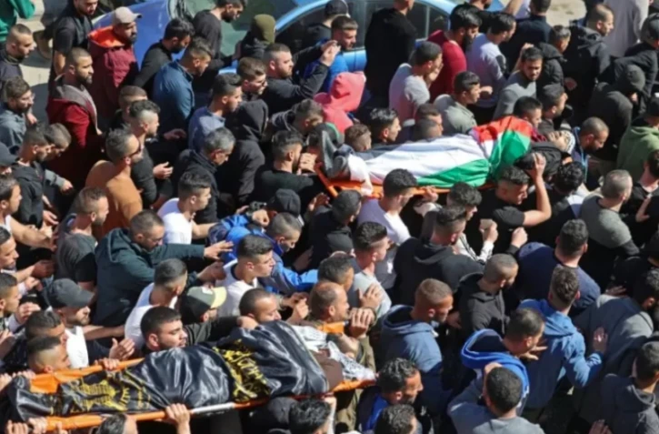 Les dépouilles de deux hommes palestiniens tués jeudi lors d'un raid israélien, sont portées par un cortège pour leurs funérailles, à Jénine, dans le nord de la Cisjordanie occupée, le 14 avril 2022 ( AFP / JAAFAR ASHTIYEH )