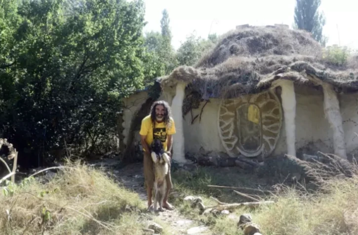 Dimche Ackov et son chien devant sa maison construite avec des matériaux locaux, près de Vélès, le 7 octobre 2023 en Macédoine du Nord ( AFP / Robert ATANASOVSKI )