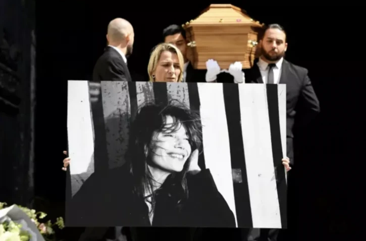 Un portrait de Jane Birkin devant son cercueil à la sortie de l'église Saint-Roch, le 24 juillet 2023 à Paris ( AFP / JULIEN DE ROSA )