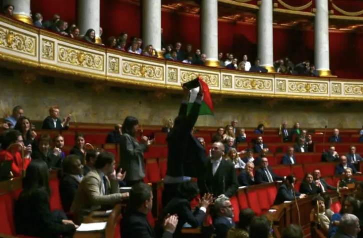 Le député LFI Sébastien Delogu brandit un drapeau palestinien dans l'hémicycle de l'Assemblée nationale, le 28 mai 2024 à Paris ( AFP / Miguel MEDINA )