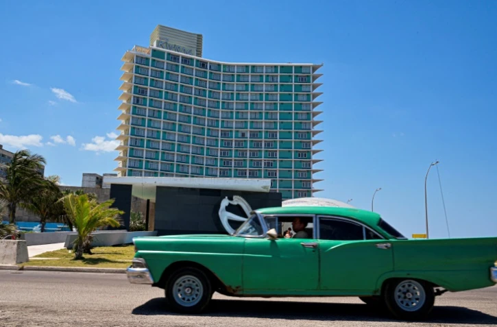 Un berline américaine passe devant l'hôtel Riviera qui a abrité un casino jusqu'à la révolution castriste de 1959, à La Havane, le 14 avril 2025
