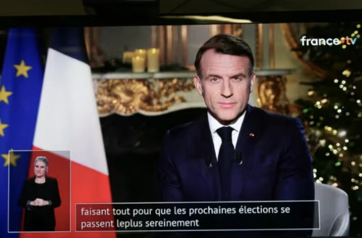 Un écran de television qui diffuse l'allocution des voeux du président Emmanuel Macron, mercredi soir le 31 décembre 2025 depuis l'Elysée ( AFP / Dimitar DILKOFF )