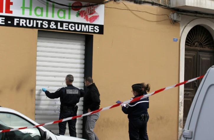 Des policiers constatent des impactes de balles sur la devanture d'un magasin d'alimentation Hallal à Propriano en Corse, le 3 février 2016 