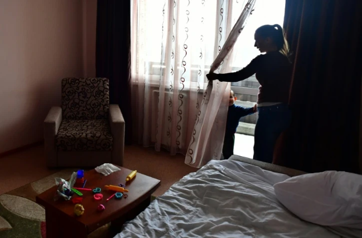 Anna Demkina dans une chambre d'hôtel avec l'un de ses enfants, le 11 janvier 2024 à Belgorod, en Russie