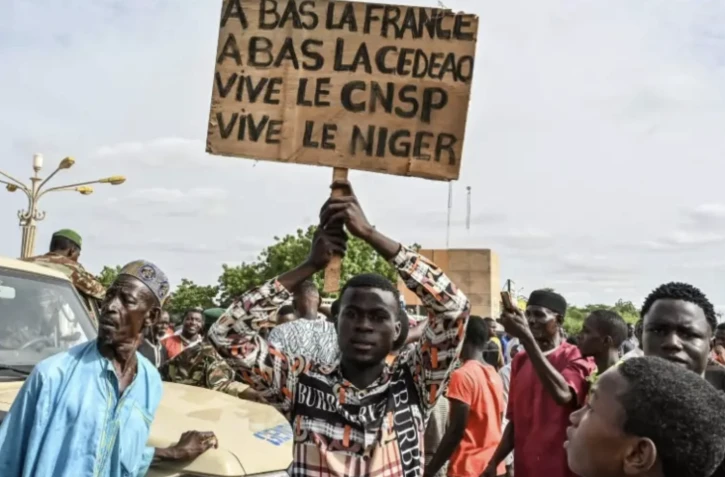 Un partisan du Conseil national pour la sauvegarde de la patrie (CNSP) du Niger tient une pancarte lors d'une manifestation devant le Stade Général Seyni Kountche à Niamey, au Niger, le 6 août 2023 ( AFP / - )