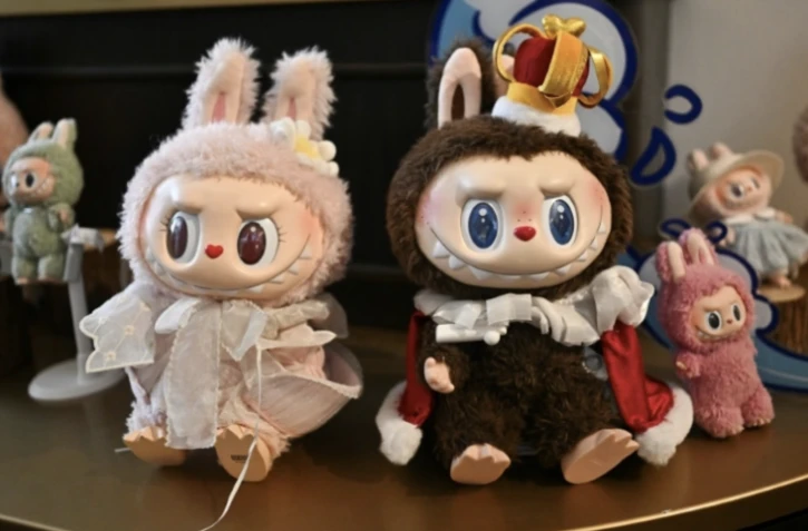 Cette photo prise le 18 juin 2025 montre les personnages Mokoko (à gauche) et Labubu dans une salle d'exposition du parc d'attractions "Pop Land" de Pop Mart à Pékin ( AFP / Pedro PARDO )