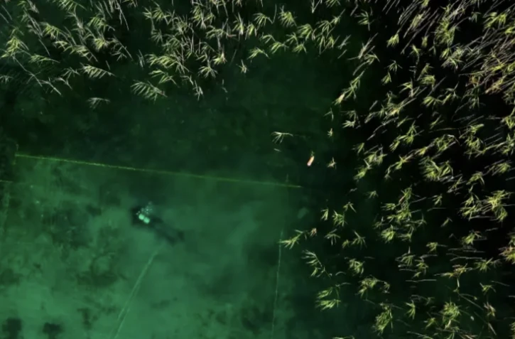 Un plongeur participe aux fouilles sous-marines du lac d'Ohrid, où se trouvent les vestiges de la plus ancienne cité lacustre, le 27 juillet 2023 à Lin, en Albanie ( AFP / Adnan Beci )