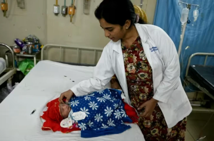 Une médecin s'occupe d'un nouveau-né dans le service maternité d'un hôpital public d'Hyderabad, en Inde, le 29 février 2024 ( AFP / Noah SEELAM )