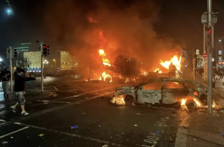 La police sécurise les lieux à Dublin après qu'une voiture de police a été incendiée lors de heurts faisant suite à une attaque au couteau le 23 novembre 2023 à Dublin