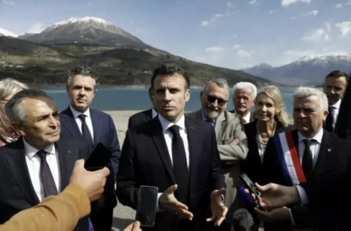 Le président Emmanuel Macron (c) fait une déclaration aux journalistes à son arrivée à Savines-le-Lac, le 30 mars 2023 dans les Hautes-Alpes ( POOL / Sebastien NOGIER )