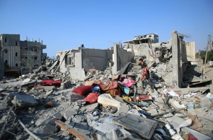 Un Palestinien récupère quelques effets personnels parmi les décombres d'un bâtiment détruit à la suite de frappes dans le centre de la bande de Gaza, le 7 novembre 2024