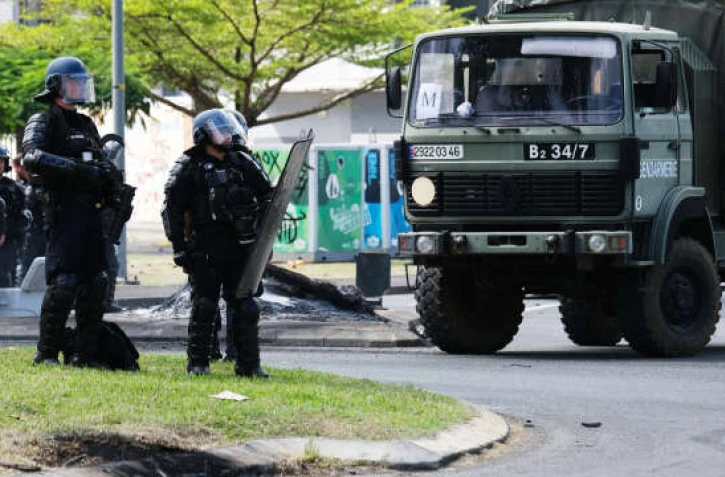 Un habitant dégage une route à Nouméa, le 15 mai 2024