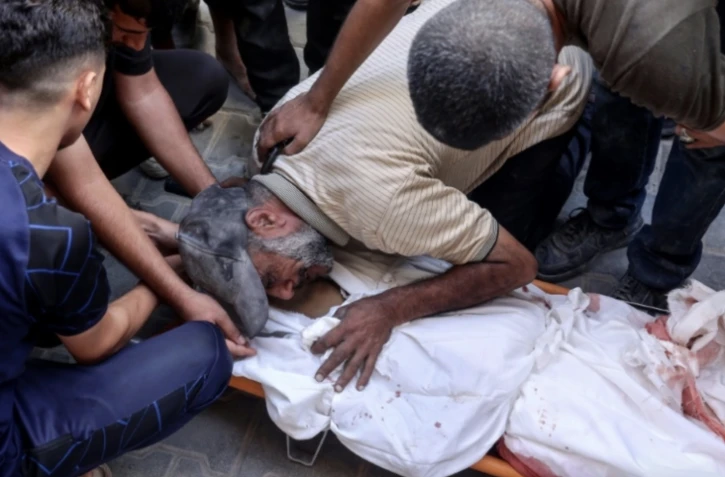 Un Palestinien pleure sur le corps d'un proche tué dans des bombardements israéliens à Nousseirat, dans le centre de la bande de Gaza, le 16 septembre 2024 ( AFP / Eyad BABA )