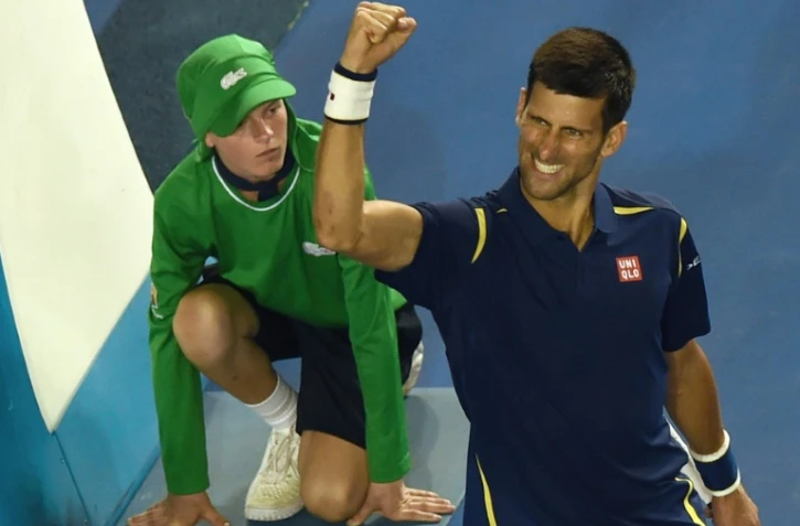 Novak Djokovic lève le bras après avoir éliminé le Japonais Kei Nishikori en quarts de finale à l'Open d'Australie, le 26 janvier 2016 à Melbourne