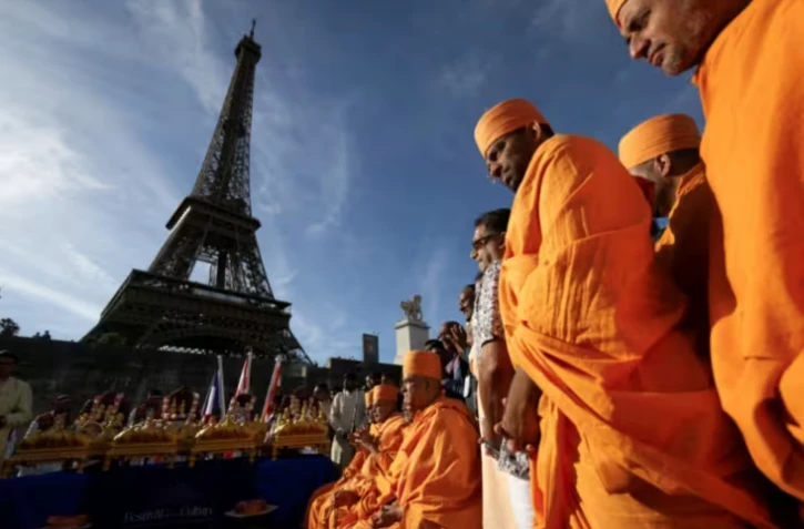 Des moines du groupe hindou Bochasanwasi Akshar Purushottam Swaminarayan Sanstha (BAPS) assistent à une cérémonie devant la Tour Eiffel à Paris, le 3 septembre 2026 ( AFP / Kenzo TRIBOUILLARD )