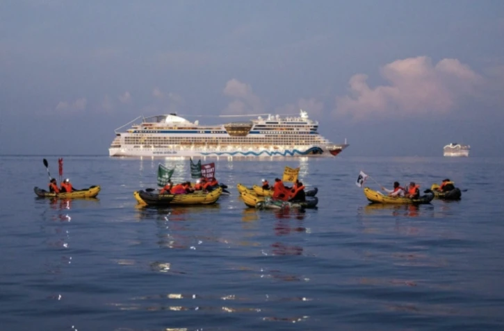 Des membres des collectifs Stop croisières et Extinction Rebellion bloquent des navires de croisière à l'entrée du port de Marseille pour dénoncer la pollution qu'ils génèrent, le 21 septembre 2024 ( AFP / CLEMENT MAHOUDEAU )