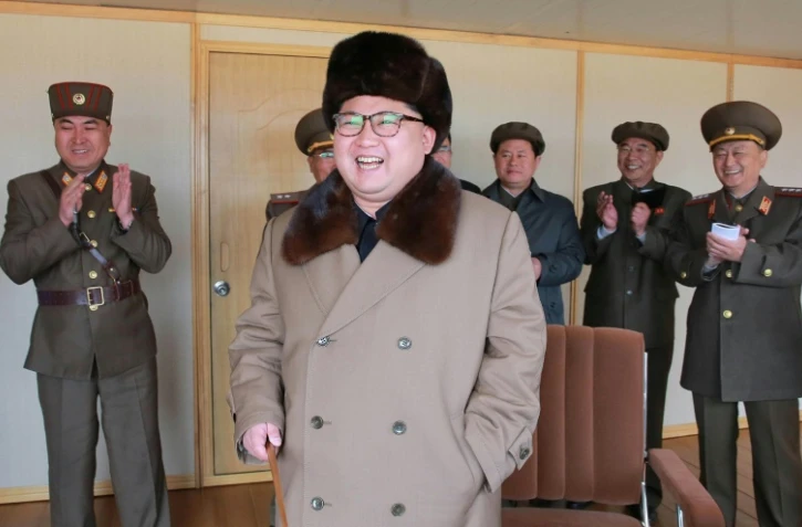 Photographie non datée transmise par l'agence de presse officielle nord-coréenne le 2 avril 2016 montrant le chef d'Etat Kim Jong-Un (c) inspectant un test de lancement d'un nouveau type de missile