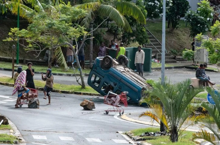 Un habitant dégage une route à Nouméa, le 15 mai 2024