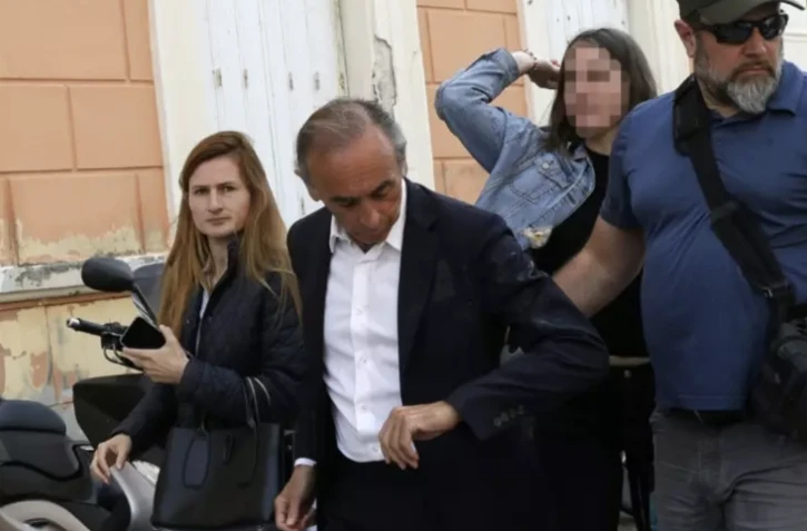 Une femme (D) jette un oeuf sur le président du parti d'extrême droite Reconquête! Éric Zemmour (G) lors d'une déambulation sur un marché, le 4 mai 2024 à Ajaccio ( AFP / PASCAL POCHARD-CASABIANCA )
