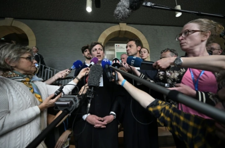 Les avocats de Joël Le Scouarnec, Maxiqume Tessier (c,g) et Thibaut Kurzawa (c,d) répondent aux questions des journalistes après la condamnation de l'ex-chirurgien pédocriminel à 20 ans de réclusion, le 28 mai 2025 à Vannes, dans le Morbihan ( AFP / Damien Meyer )