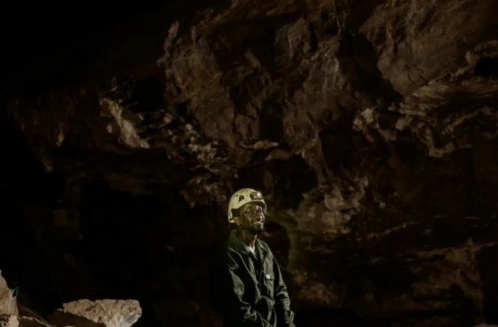 Le géologue sud-africain Tebogo Makhubela dans la grotte de Rising Star en Afrique du Sud le 26 juin 2024 ( AFP / MARCO LONGARI )