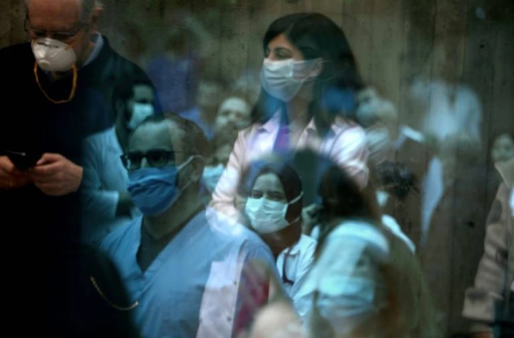 L'équipe de soignants de l'hôpital Saint-George à Beyrouth écoute un groupe de musique qui se produit pour eux, à travers une paroi vitrée, le 24 avril 2020