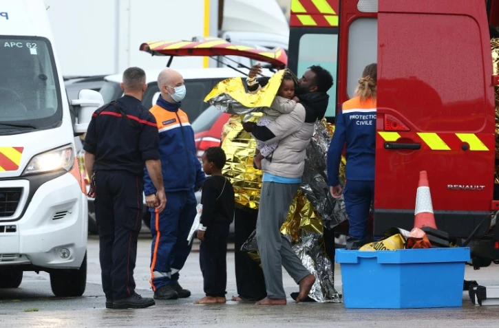 Des rescapés revêtent  des couvertures de survie  à la suite du naufrage de leur canot transportant des migrants qui tentaient de traverser la Manche depuis la France vers le Royaume-Uni, à Calais, dans le nord de la France, le 28 septembre 2026