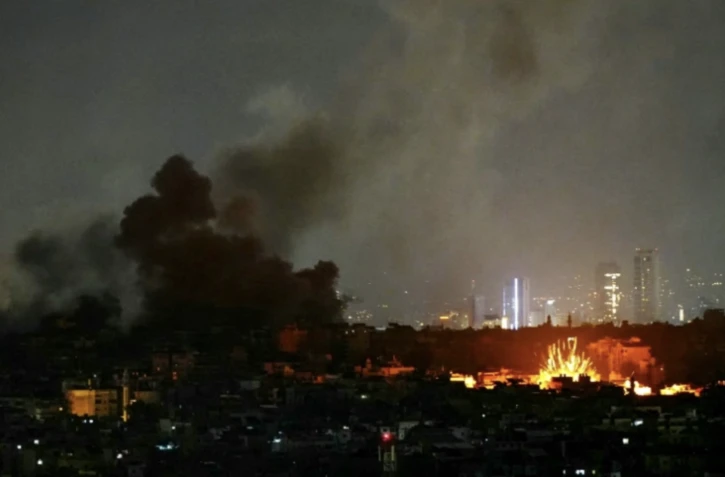 De la fumée s'élève et une boule de feu jaillit du site des frappes aériennes qui ont visé la banlieue sud de Beyrouth le 24 novembre 2024 ( AFP / - )