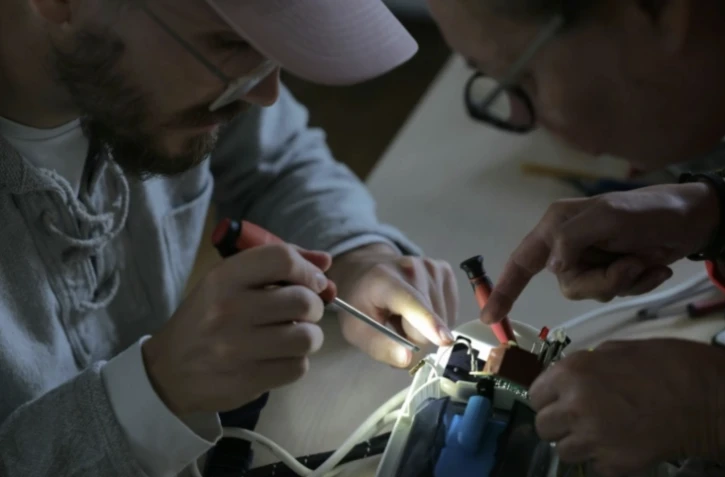 Des bénévoles réparent un appareil électrique dans un "repair café" à Paris, le 17 octobre 2024 ( AFP / Thomas SAMSON )