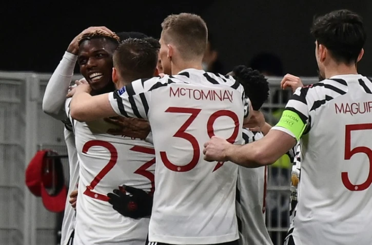La joie du milieu de terrain de Manchester United, le Français Paul Pogba, félicité par ses coéquipiers après avoir ouvert le score contre l?AC Milan, lors de leur match retour de Ligue Europa, le 18 mars 2021 au stade San Siro