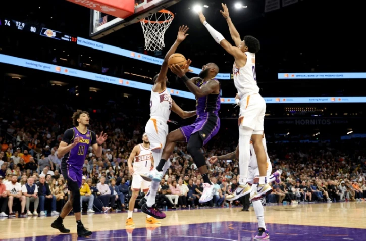 LeBron James (c.) est mis sous pression par Kevin Durant lors du match de NBA entre les Los Angeles Lakers et les Phoenix Suns, Ă Phoenix, le 28 octobre 2024