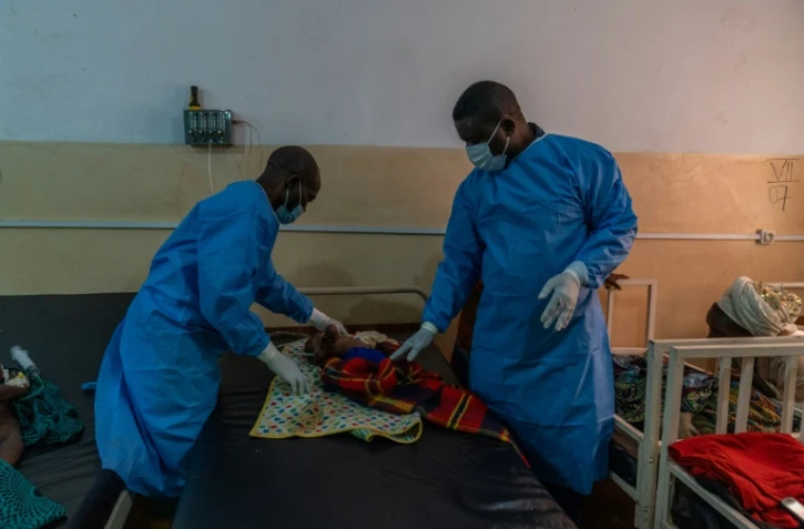 Le Dr Robert Musole (à droite), directeur médical de l'hôpital de Kavumu, en République démocratique du Congo, ausculte un nourrisson atteint d'une forme grave de mpox, le 24 août 2024