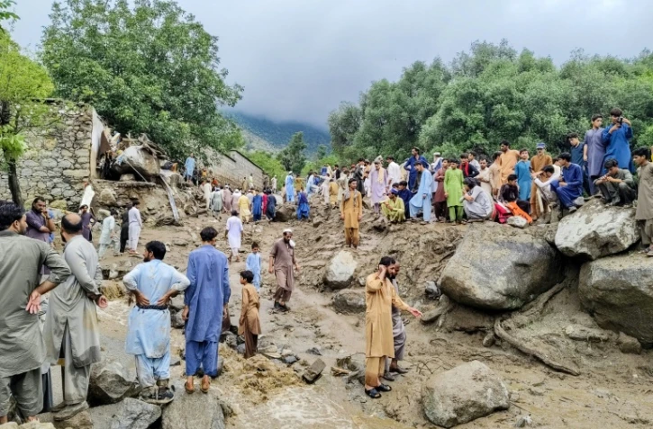 Des personnes se rassemblent sur le site d'une crue soudaine après de fortes pluies de mousson à Salarzai Tehsil, dans le district de Bajaur au Pakistan, le 15 août 2025
