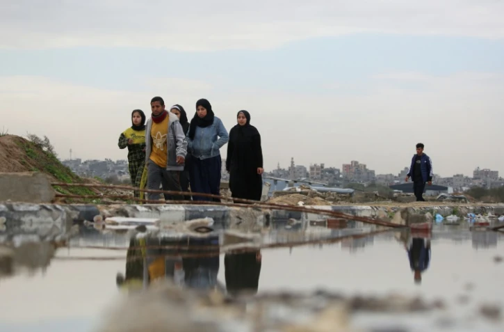 Des civils palestiniens marchent dans al-Mughraqa, dans le centre de la bande de Gaza, le 13 février 2025