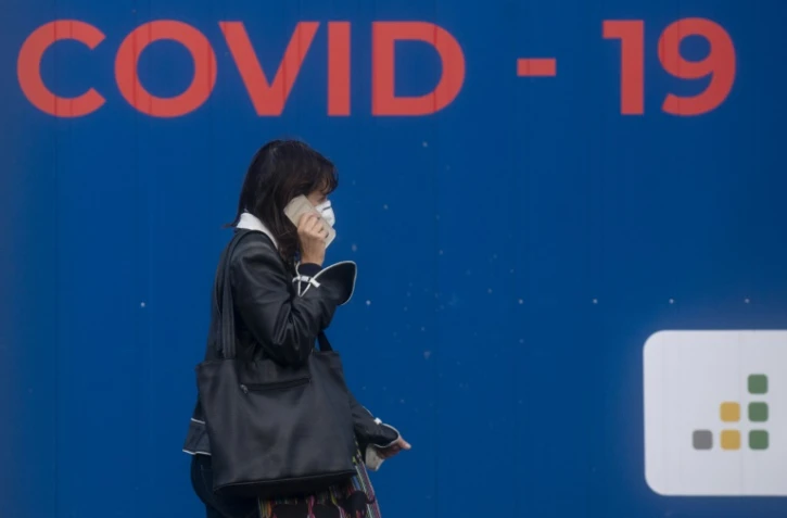 Une femme portant un masque devant un stand de dépistage au Covid-19 le 24 septembre 2020 à Prague 