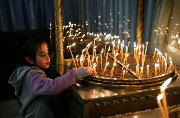 Un enfant allume des bougies à la basilique de la Nativité à Bethléem, en Cisjordanie occupée, le 23 décembre 2019