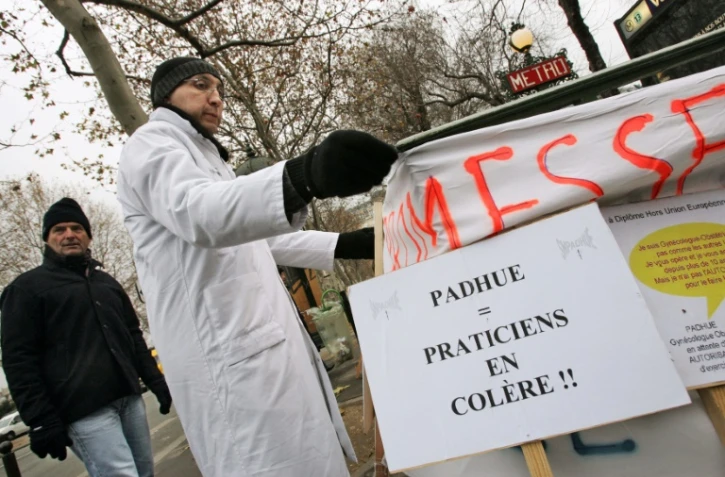 Des médecins à diplôme étranger (hors UE) manifestent devant Matignon à Paris, le 28 décembre 2005, pour dénoncer le statut précaire et le travail sous-payé