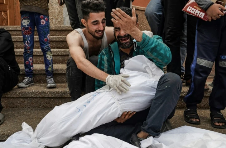 Des Palestiniens pleurent leurs proches tués dans un bombardement israélien, le 28 décembre 2023 à l'hôpital Nasser de Khan Younès