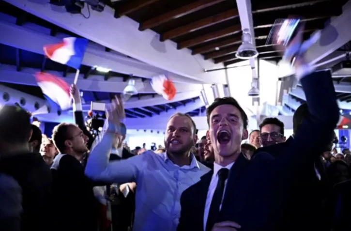 Des militants du Rassemblement national célèbrent l'annonce de la dissolution de l'Assemblée nationale par le président Emmanuel Macron, le 9 juin 2024 à Paris ( AFP / JULIEN DE ROSA )