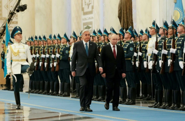 Le président russe Vladimir Poutine (d) et son homologue kazakh Kassym-Jomart Tokaïev passent en revue la garde d'honneur lors d'une cérémonie de bienvenue, le 9 novembre 2023 à Astana, au Kazakhstan
