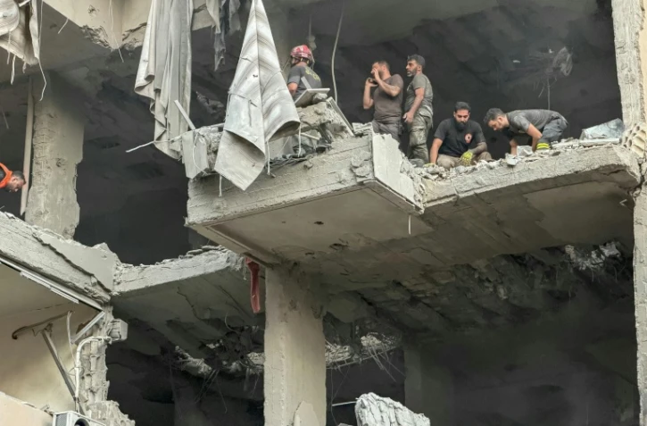 Des secouristes dans l'immeuble touché par une frappe d'Israël, qui a affirmé avoir visé le chef d'état major du Hezbollah, dans la banlieue sud de Beyrouth, le 23 novembre 2025