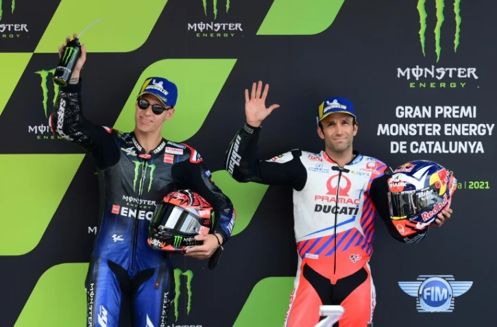 Les pilotes français Fabio Quartararo (Yamaha), auteur de la pole position, et Johann Zarco (Ducati-Pramac), célèbrent sur le podium à l'issue des qualifications pour le GP MotoGP de Catalogne, le 5 juin 2021 sur le circuit de Montmelo, dans la banlieue de Barcelone