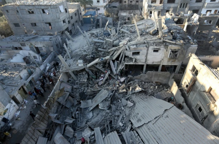 Des Palestiniens inspectent les dégâts causés par les frappes israéliennes à al-Zawayda, dans le centre de la bande de Gaza, le 30 décembre 2023