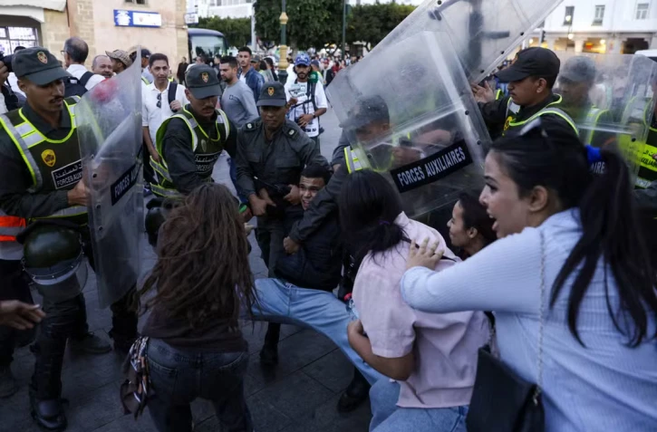 Des membres des forces de sécurité arrêtent un manifestant lors d’un rassemblement de jeunes à Rabat, le 29 septembre 2025, réclamant des réformes dans les secteurs de la santé publique et de l’éducation. ABDEL MAJID BZIOUAT / AFP 