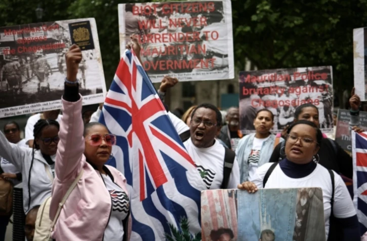 Des membres de la communauté chagossienne rassemblés devant la Haute Cour de Londres, le 22 mai 2025, pour protester contre la signature de l'accord de restitution par le Royaume-Uni des îles Chagos à Maurice ( AFP / HENRY NICHOLLS )