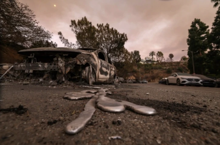 Une voiture fondue, détruite par les flammes dans le quartier de Pacific Palisades, en Californie le 10 janvier 2025 ( AFP / VALERIE MACON )