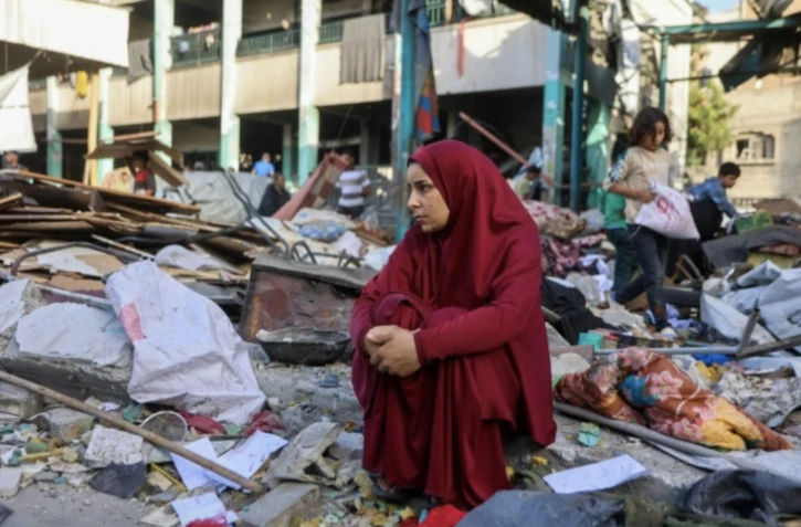 Une femme est assise au milieu des décombres après le bombardement d'une école à Gaza-ville, le 26 mai 2025 ( AFP / Omar AL-QATTAA )
